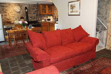 Large sofas sit in front of the wood-burner.