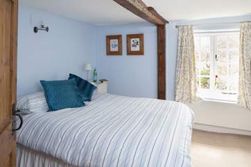 This tranquil double bedroom looks out over the garden at the back of the cottage.