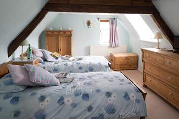 The twin bedroom at the top of the cottage on the second floor, children can look out of the window at the steam train that runs past the side of the garden.