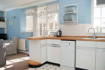 The kitchen-area has wooden work surfaces, a small dishwasher and plenty of cupboard space.
