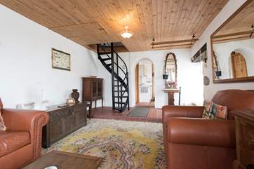 The sitting-room has a steep spiral staircase to the first floor bedroom.
