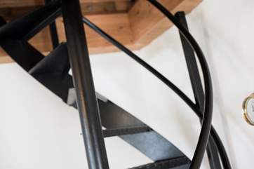 Steep spiral stairs lead up to the dressing room and bedroom.