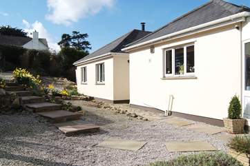 From the car port and gravelled parking-area at the top, steps lead down through the newly landscaped front garden to both entrances.