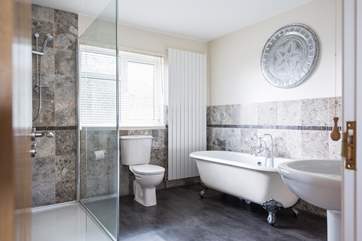 The family bathroom includes a large walk-in shower as well as a free-standing roll-top bath.