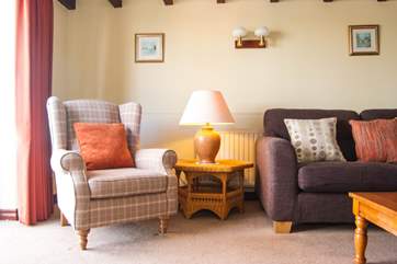 Table lamps and cushions add to the comfort in the sitting-room.