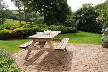 The patio is tucked to the side of the house in a sheltered position with stunning views down the valley.