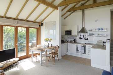The light and spacious open plan living-room has a well-equipped kitchen and ample space to dine.