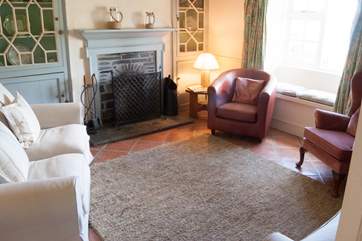 The sitting-room has comfy chairs and sofas around a cosy open fire and fabulous views.