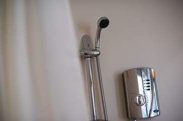 An adjustable shower head in the wet-room.
