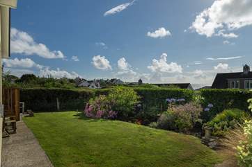 The pretty garden has an area of lawn below the raised deck.