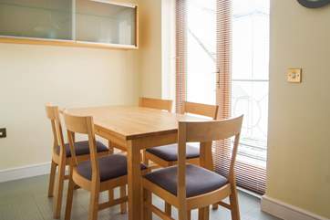 The breakfast-table in the kitchen is by French doors that open onto a balcony.