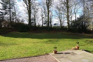The large garden in front of the cottage, bounded on all sides by a mixture of traditional hedges and post and rail fencing.