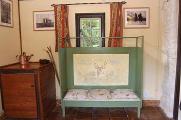 The large entrance hall has this lovely settle to sit on to pull off those walking boots. This is a great space for your dog too, especially if it gets muddy.