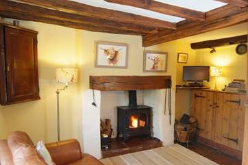 This beamed room is the heart of the cottage. It has a wood-burning stove and a comfortable sofa to relax in at the end of a day out walking.
