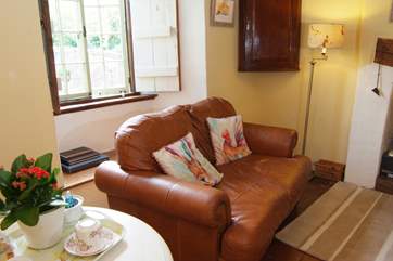 There is a little round dining table and chairs in the corner of the room.