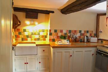 The kitchen tucks along one wall in the open plan living space in the cottage.