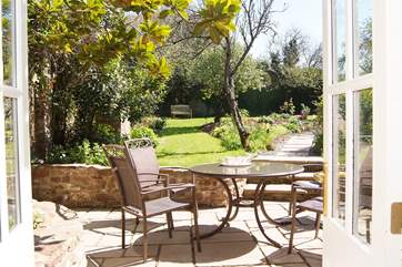 The patio is a great sun-trap and with the French windows wide open the light fills the living-room. You can see the walled garden beyond