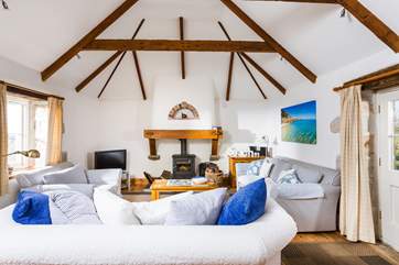 The living-room has three sofas around the cosy wood-burner.