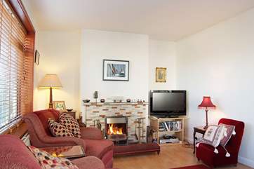 The sitting-room has a flat screen television and an open fire.