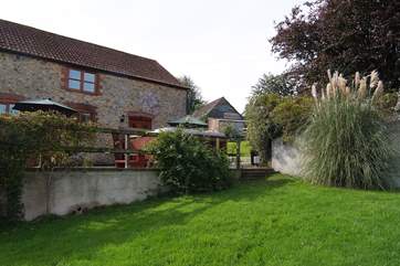 The hot tub is on the terrace with the garden in front.