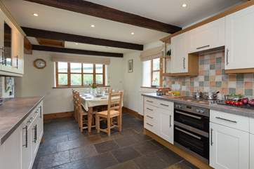 The farmhouse-style kitchen has flagstone floors and is equipped as a home-from-home.