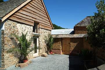 The courtyard at the side of the cottage is surrounded by a tile-topped, traditionally constructed cob wall, and leads round to the back garden.