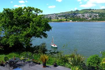 Looking down from the balcony on the small patio and river below. The boat belongs to a neighbour.