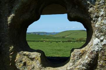A view of the coastline at Rumps Point, looking through one of the decorative quadrofoils outside the cottage.