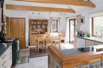 The open plan kitchen/dining-area has a working Aga and modern electric hob.