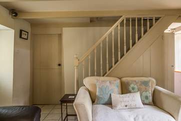 The cottage-style stairs lead up from the sitting-room.