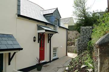 A shallow flight of steps lead from the parking-area to Oyster Cottage, a modern end-of-terrace property much bigger in reality than it looks in the picture.