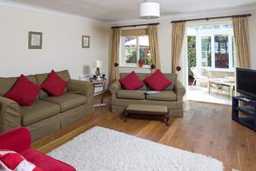 There are three comfortable sofas to choose from at one end of this spacious sitting/dining room.