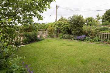 The enclosed front garden has beautiful flower borders and shrubs.