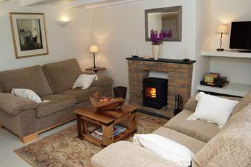 The sitting-room is furnished beautifully with cosy sofas flanking the wood-burner.