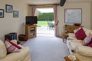 The spacious sitting-room has French windows which open onto a lovely private patio.