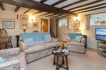 Another view of the sitting-room - plenty of comfy seating. You can glimpse the turning cottage stairs to the bedrooms.