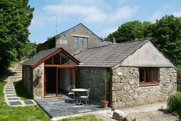 The exterior of the cottage, accessed by steps down from the parking-area.