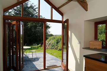 Folding French doors open onto the sunny private patio outside.