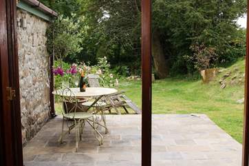 Folding French doors open onto the sunny private patio outside, a lovely place to sit and relax over a meal or simply to read the latest best seller in this peaceful setting.