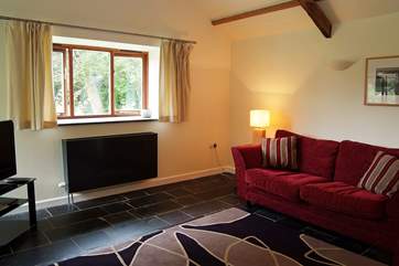 The pitched roof and exposed beams give this room a lovely light and spacious feel, it also has garden views from both windows.