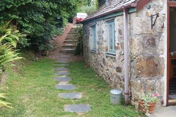 The exterior of the cottage, accessed by steps down from the parking-area.
