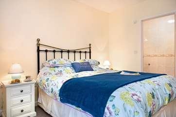 Pretty linens adorn the bed in the first floor bedroom.