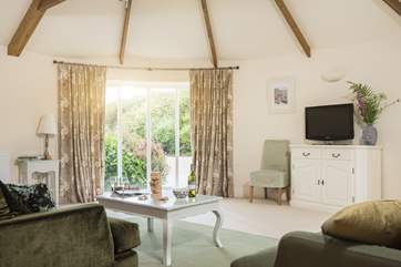 The living-room is spacious and light due to the large windows and high ceiling.