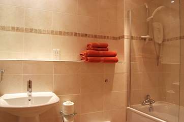 The family bathroom is spacious and has a fitted shower above the bath.