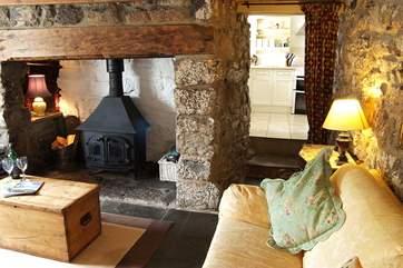 The sitting-room has a cosy wood-burner in the inglenook fireplace and comfy sofas.