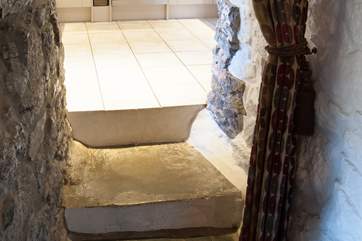 There are two steps up to the kitchen from the sitting-room and another one to the downstairs loo and back door.