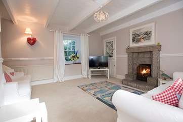 The second sitting-room with a TV and roaring open fire.
