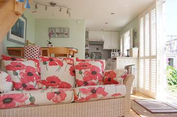The comfy sofa has cheerful bright covers.
