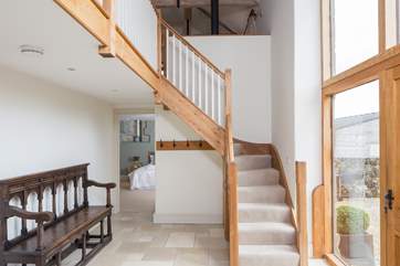Steps lead from the front door to the open plan first floor in this reverse-level barn conversion. The master bedroom is in the background.