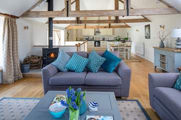 The wonderful open plan first floor living-area with cosy wood-burner, high beams and wooden floor.
